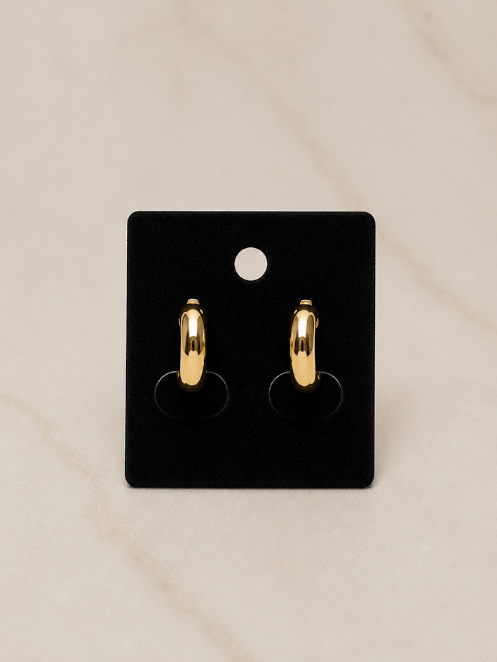 Majesty Mini Earrings displayed on black card, featuring a sleek dome silhouette in polished gold finish.