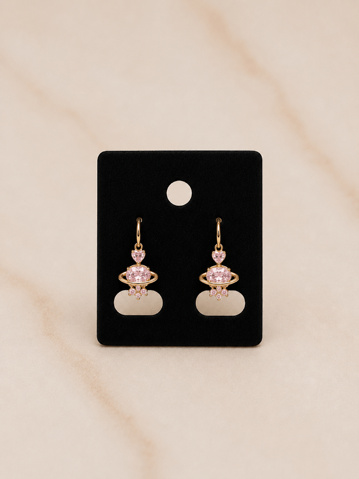 Golden Blush Heart Earrings featuring pink zirconia on a black card display.