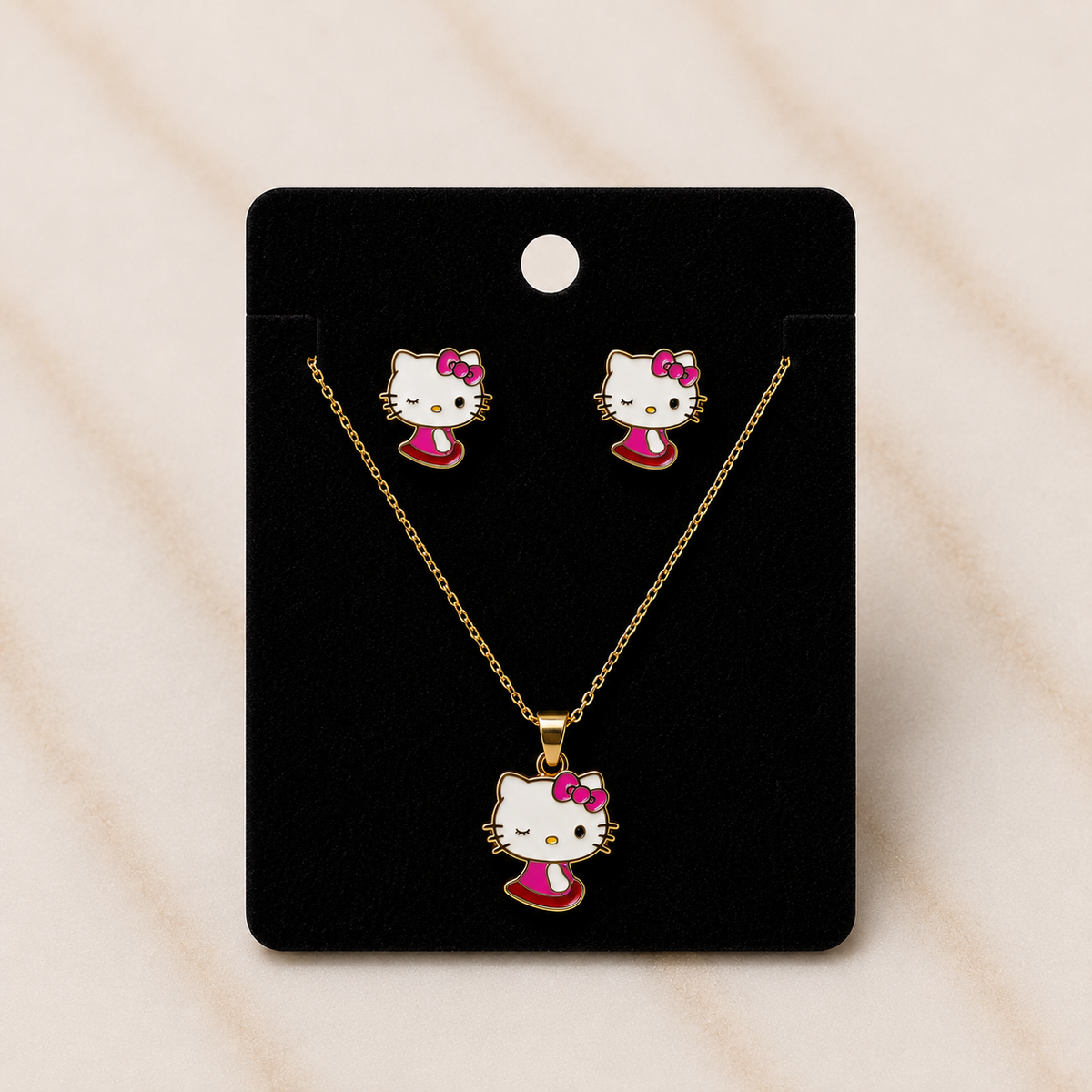 The Charme' Kitty Legacy Set jewelry collection featuring gold-tone necklace and earrings with charm designs.