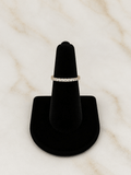 The Eternity Band Ring displayed on a black ring stand, showcasing its stunning cubic zirconia stones.