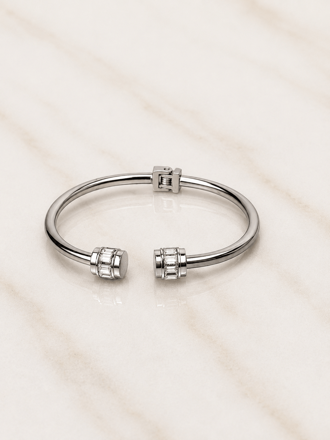 The Royal Radiance Cuff featuring a sleek design with baguette-cut crystal barrel accents on a marble surface.