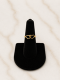 The Golden Bond Ring featuring a double heart design on a black velvet ring holder.
