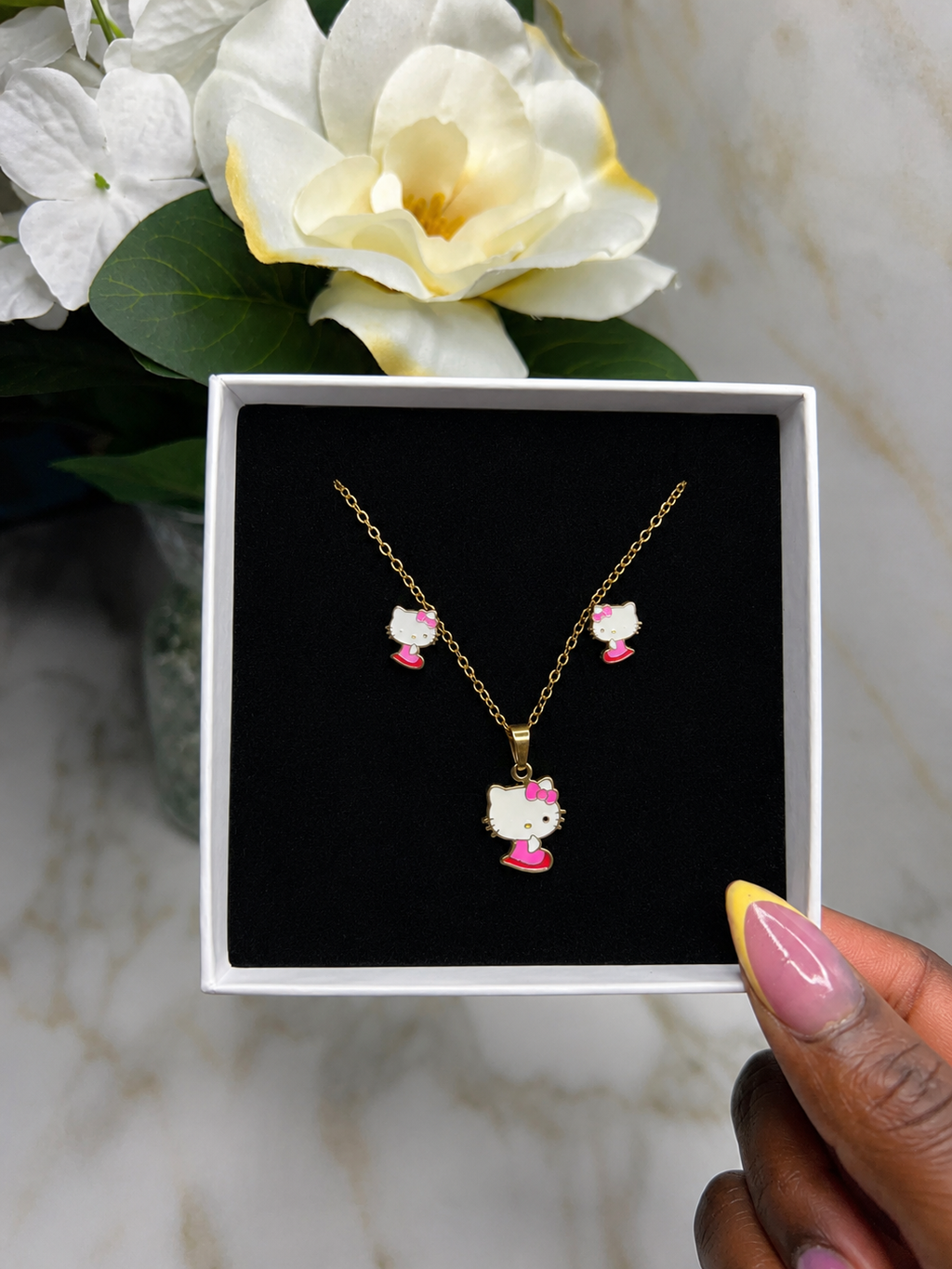 The Charme' Kitty Legacy Set featuring a gold-tone necklace and earrings with charm designs, perfect for young royalty.