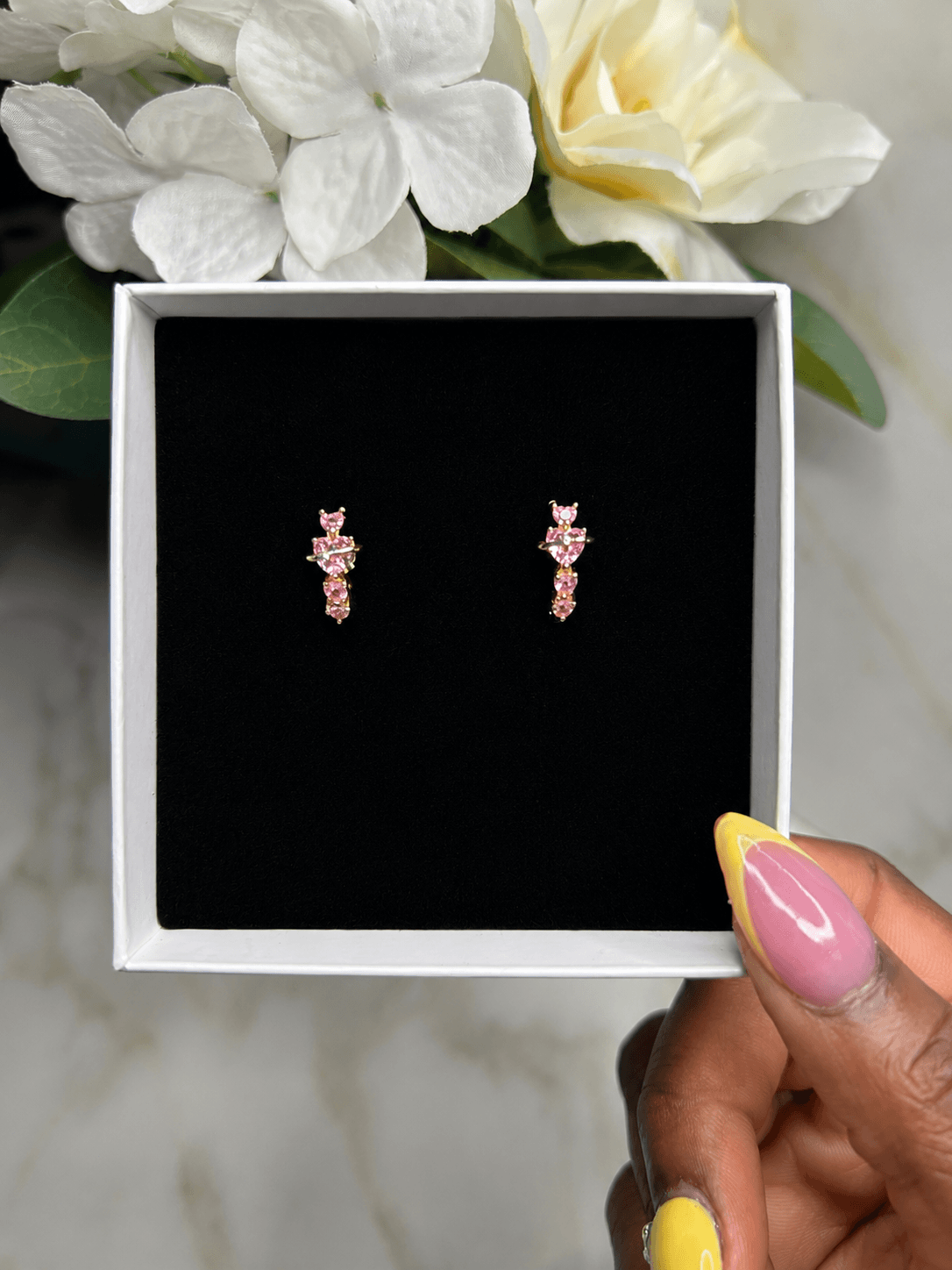 Golden Blush Heart Earrings displayed in a gift box with pink zirconia, showcasing elegance and sparkle.
