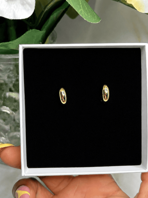 Majesty Mini Earrings showcased in a black box, featuring a sleek dome silhouette and polished gold finish.