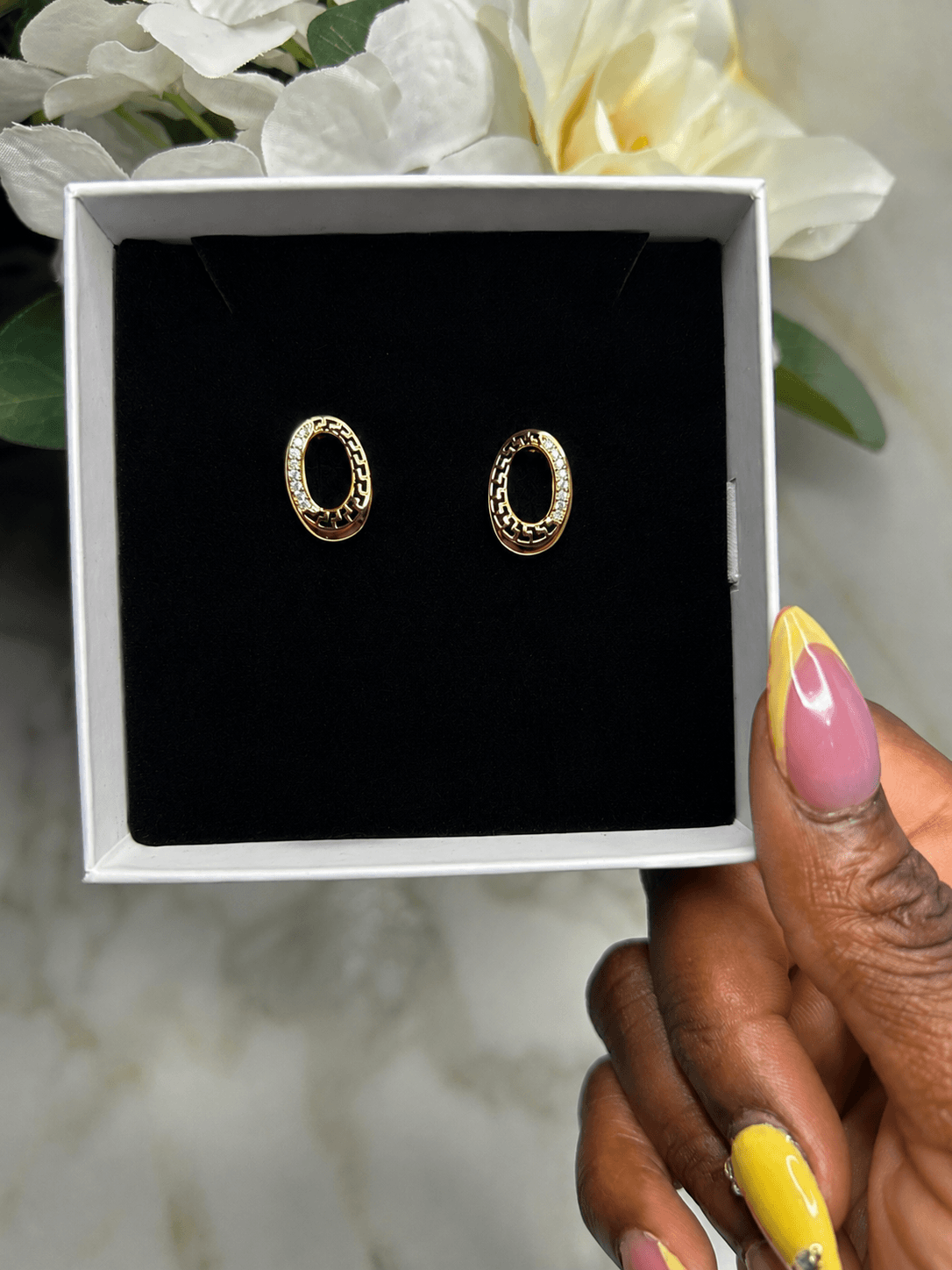 The Eternal Circle Earrings displayed in a stylish box, showcasing their elegant gold design and sparkling accents.