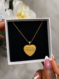 The Royal Heart Necklace displayed in a box, featuring a gold heart pendant with an engraving.